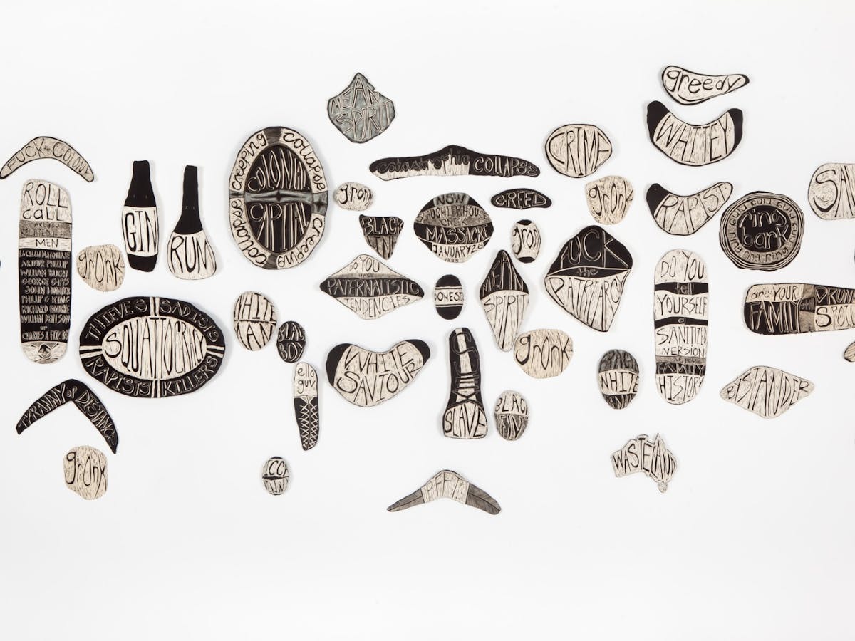Ceramic pieces in various shapes, with words associated with colonisation and stereotypes