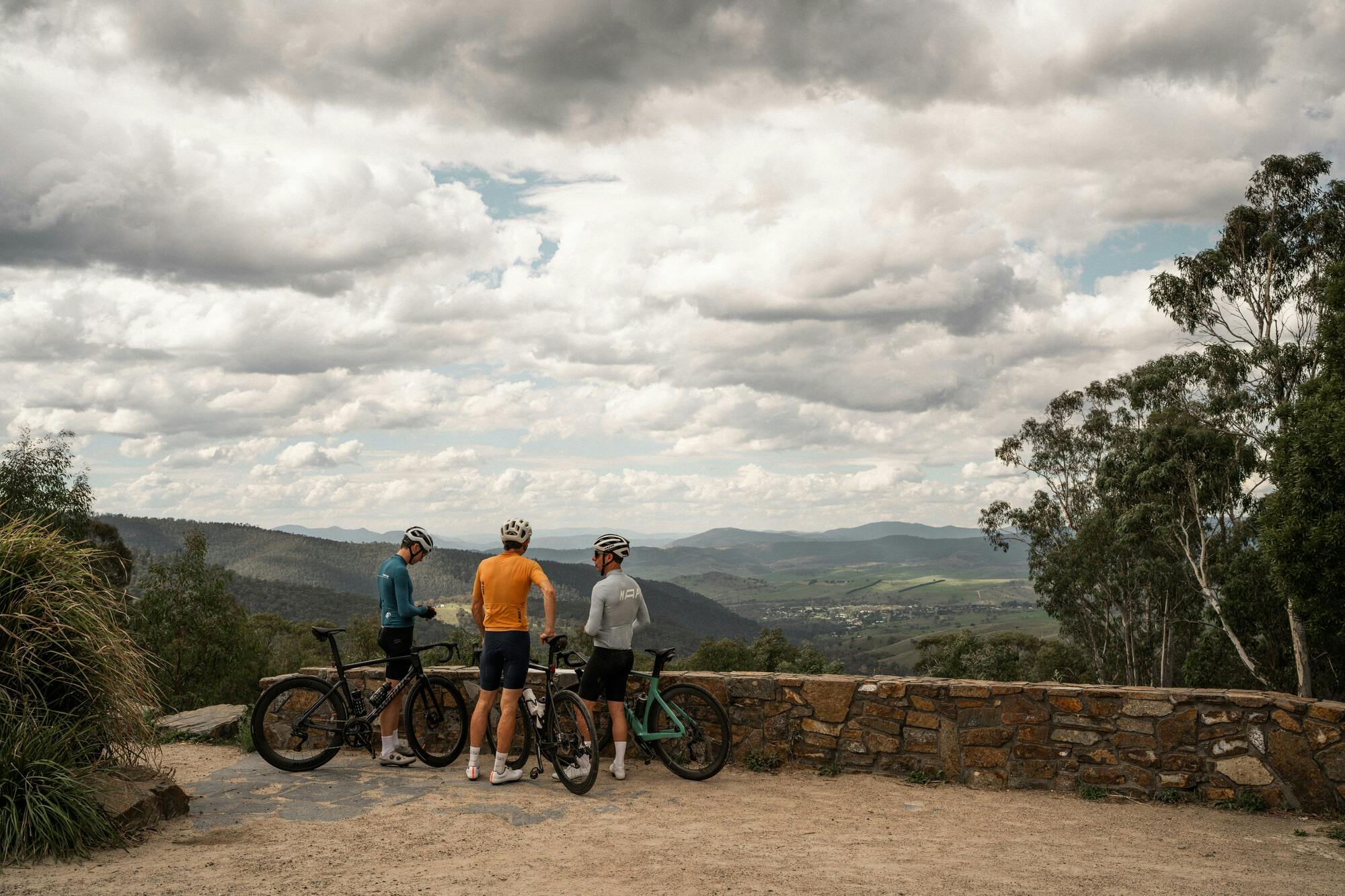 Three cyclists taking a break at the Mt Kosciuszko Lookout on the Dinner Plain 7 Peaks Challenge