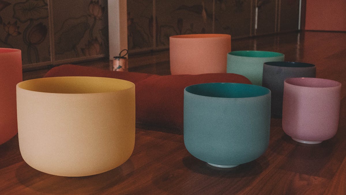 Colourful sound bowls on the floor of a yoga studio
