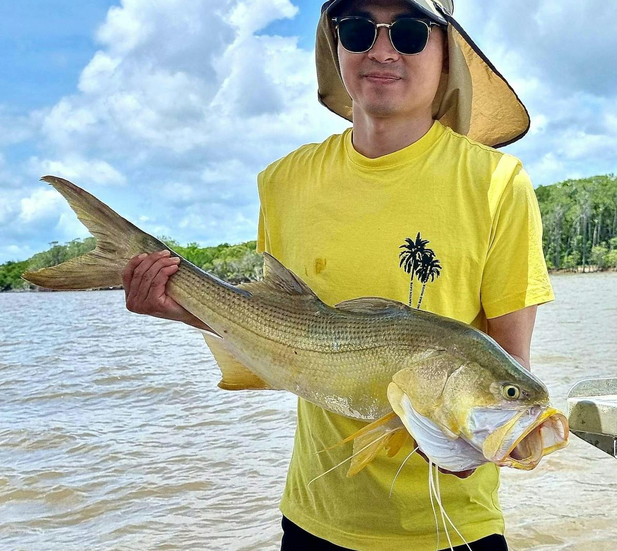 Man holding a large threadfin salmon caught with Gone Fishing Cairns.