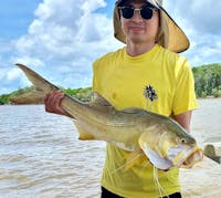 Man holding a large threadfin salmon caught with Gone Fishing Cairns.