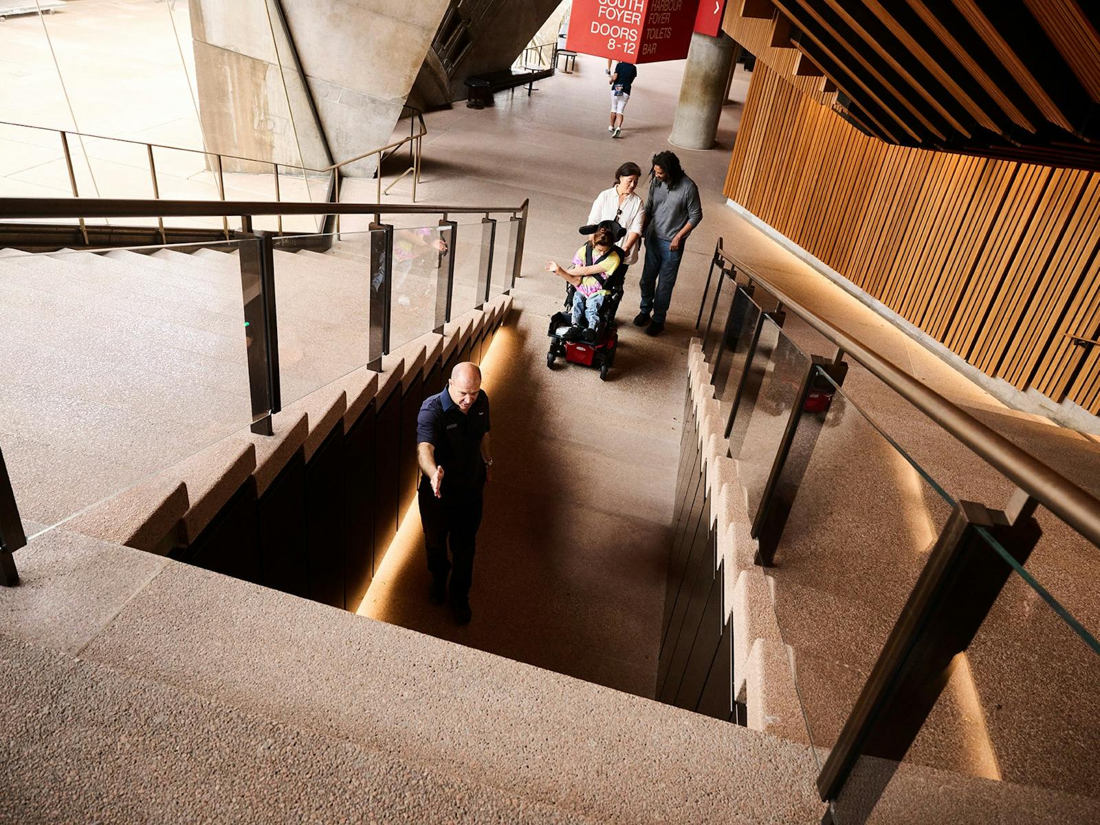 車椅子に乗った若い男性とその介護者がアクセス可能なトンネルに入る