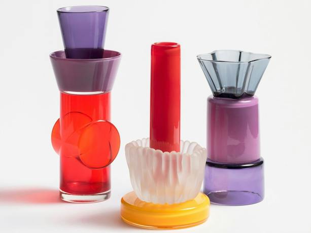 Photograph of three brightly coloured glass objects on a white background
