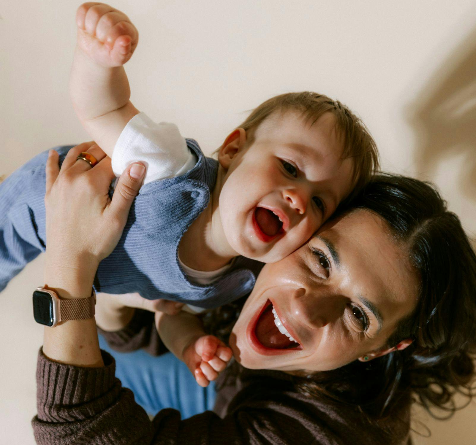 Womand holding baby and both laughing
