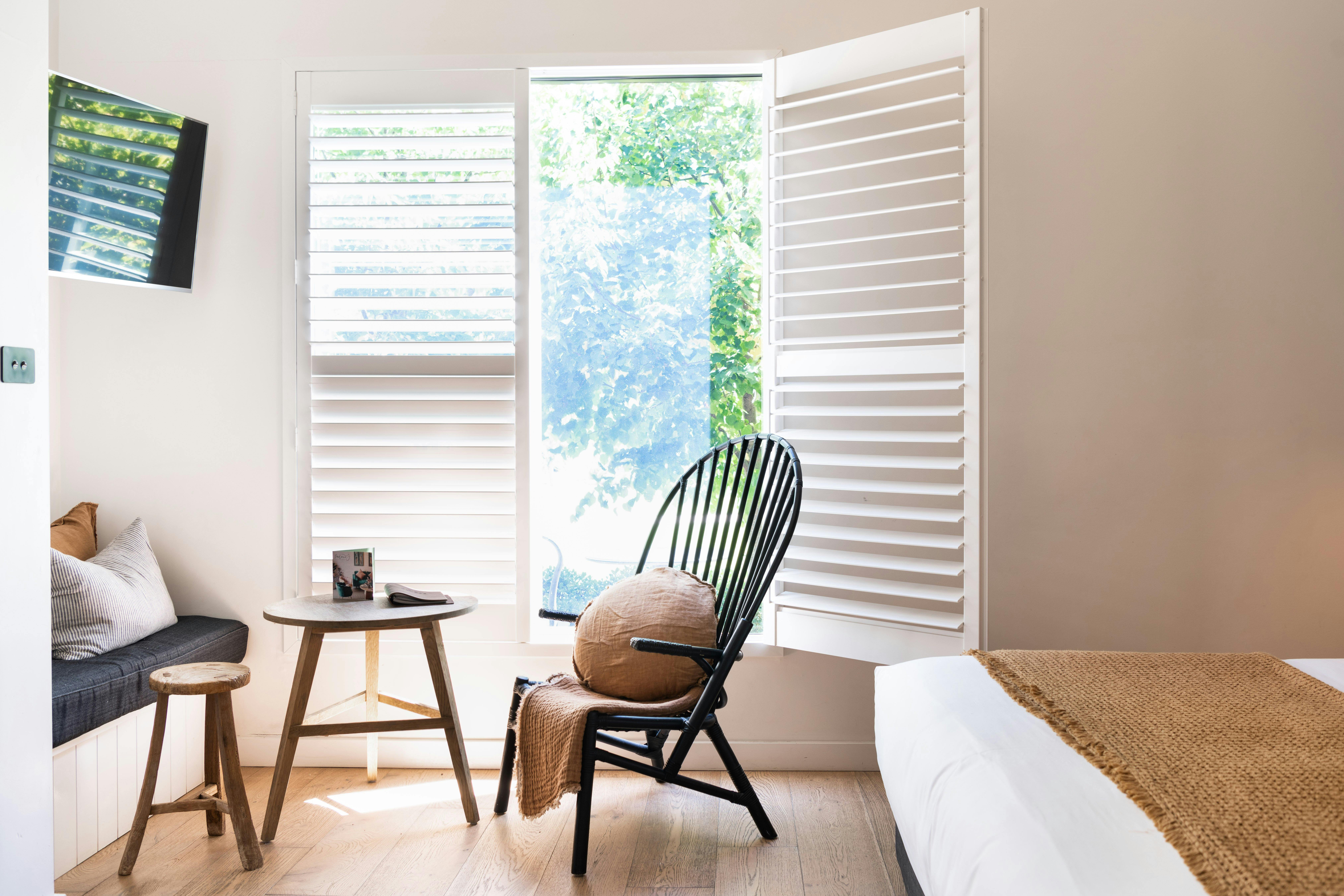 Cosy chair beside a window in The Sir George's accommodation
