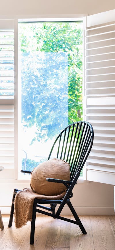 Cosy chair beside a window in The Sir George's accommodation