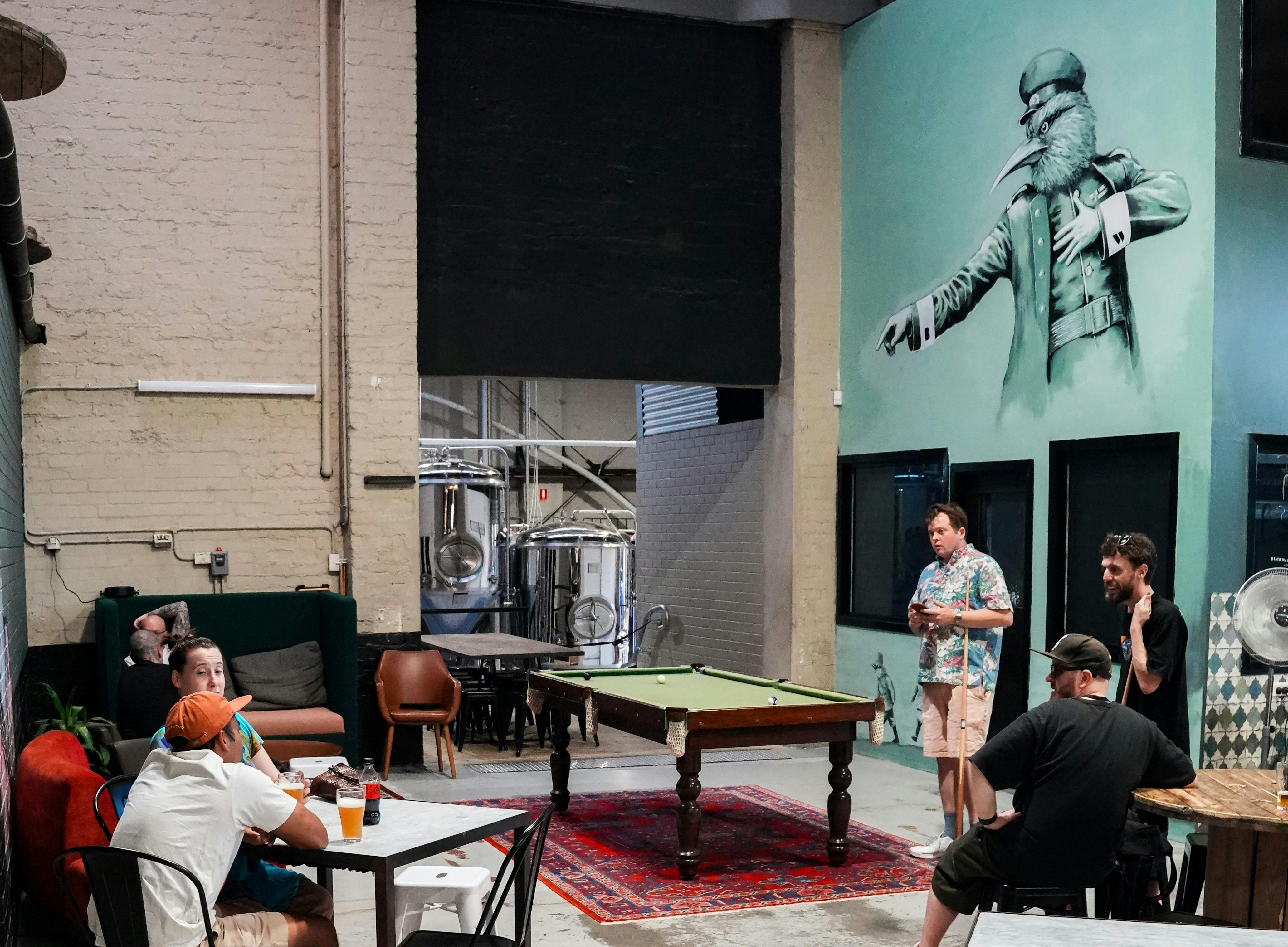 A mural of one of our bird characters pointing towards the brewery