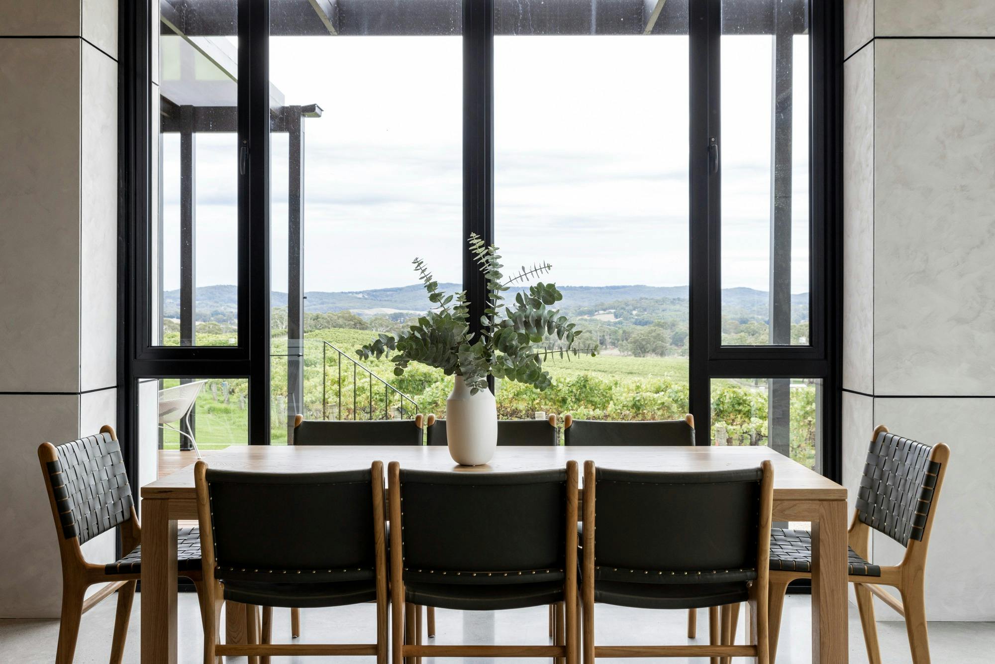 table and floor to ceiling windows of breathtaking views of Balhannah vineyards