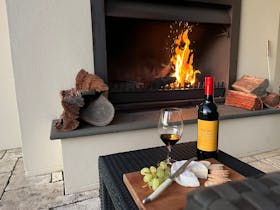 Open fire with bottle of Tanunda House wine and cheese platter
