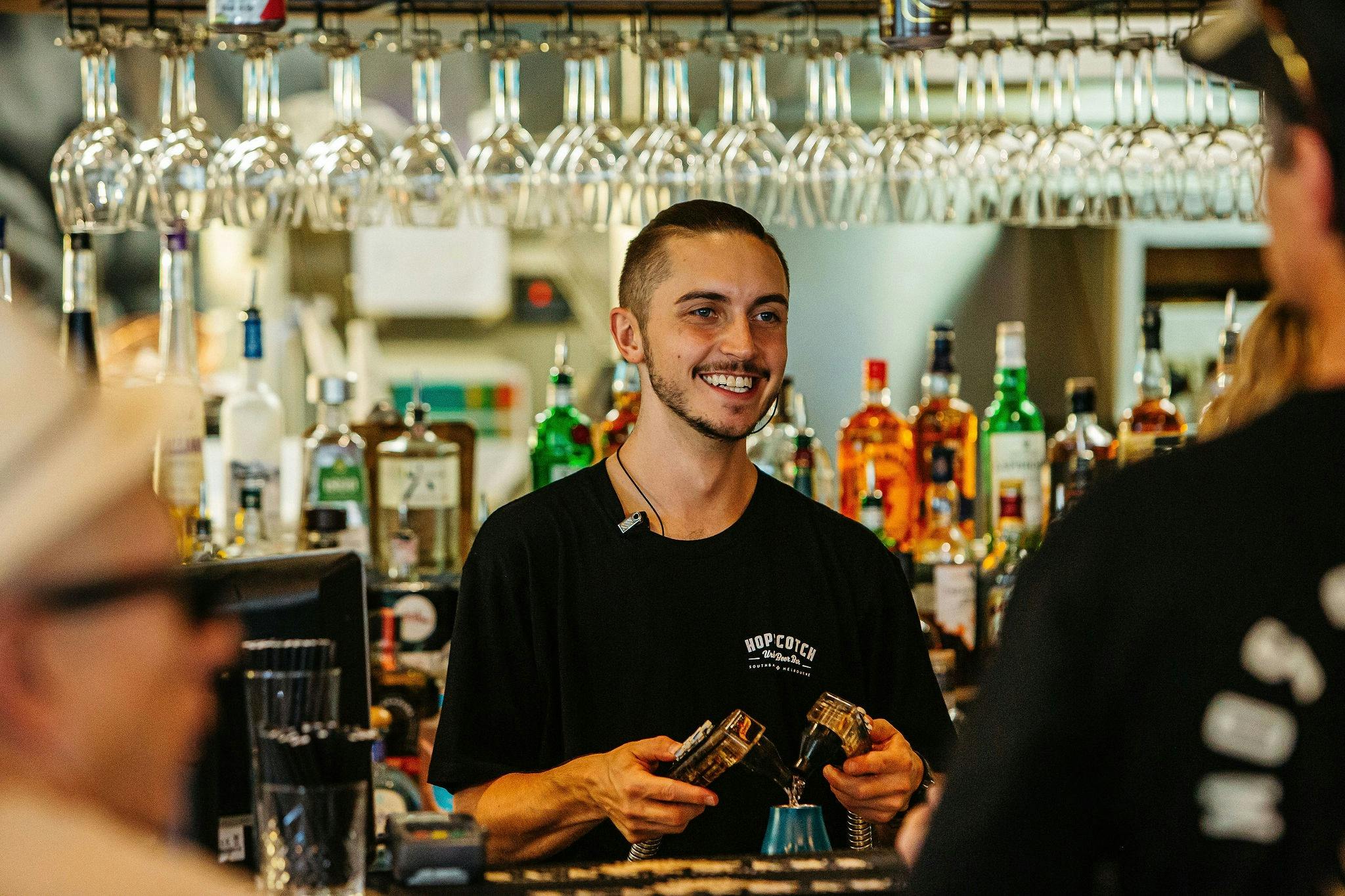Barman serving drinks from the tap
