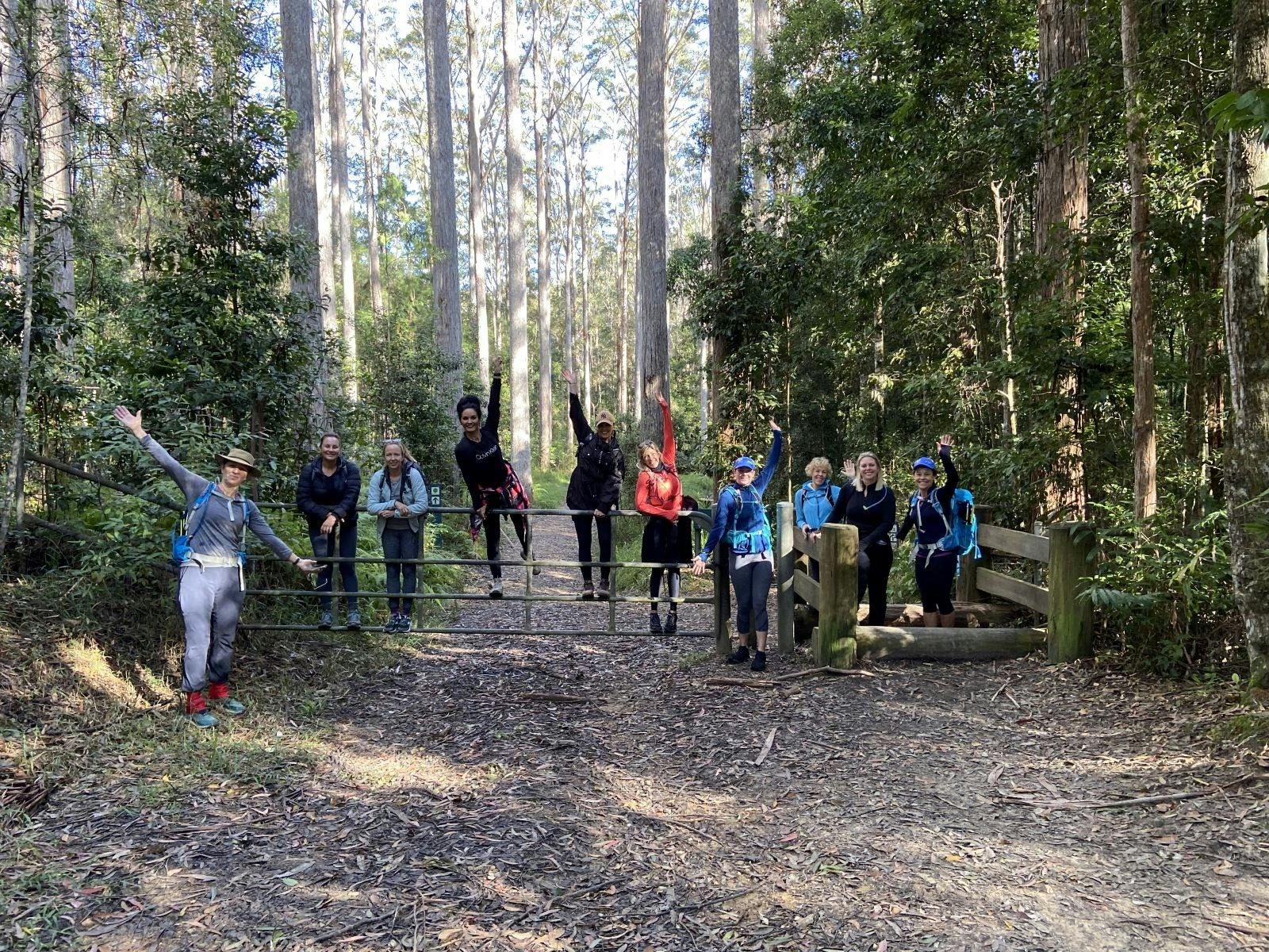 Women celebrating at the end of a hike at entrance to National PArk Women celebrating at the end of a hike at entrance to National PArk
