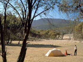 Photo of landscape with tent and two people in distance
