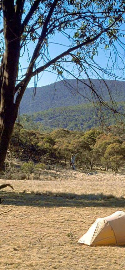 Photo of landscape with tent and two people in distance