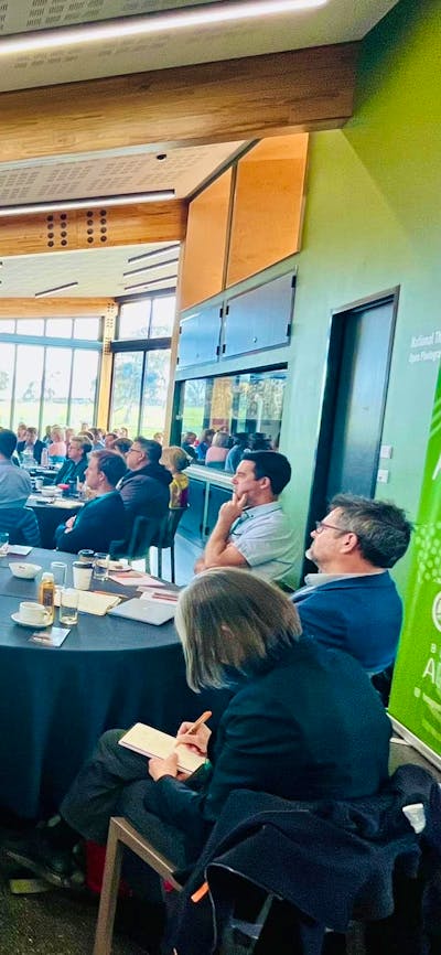 A group of people facing a speaker