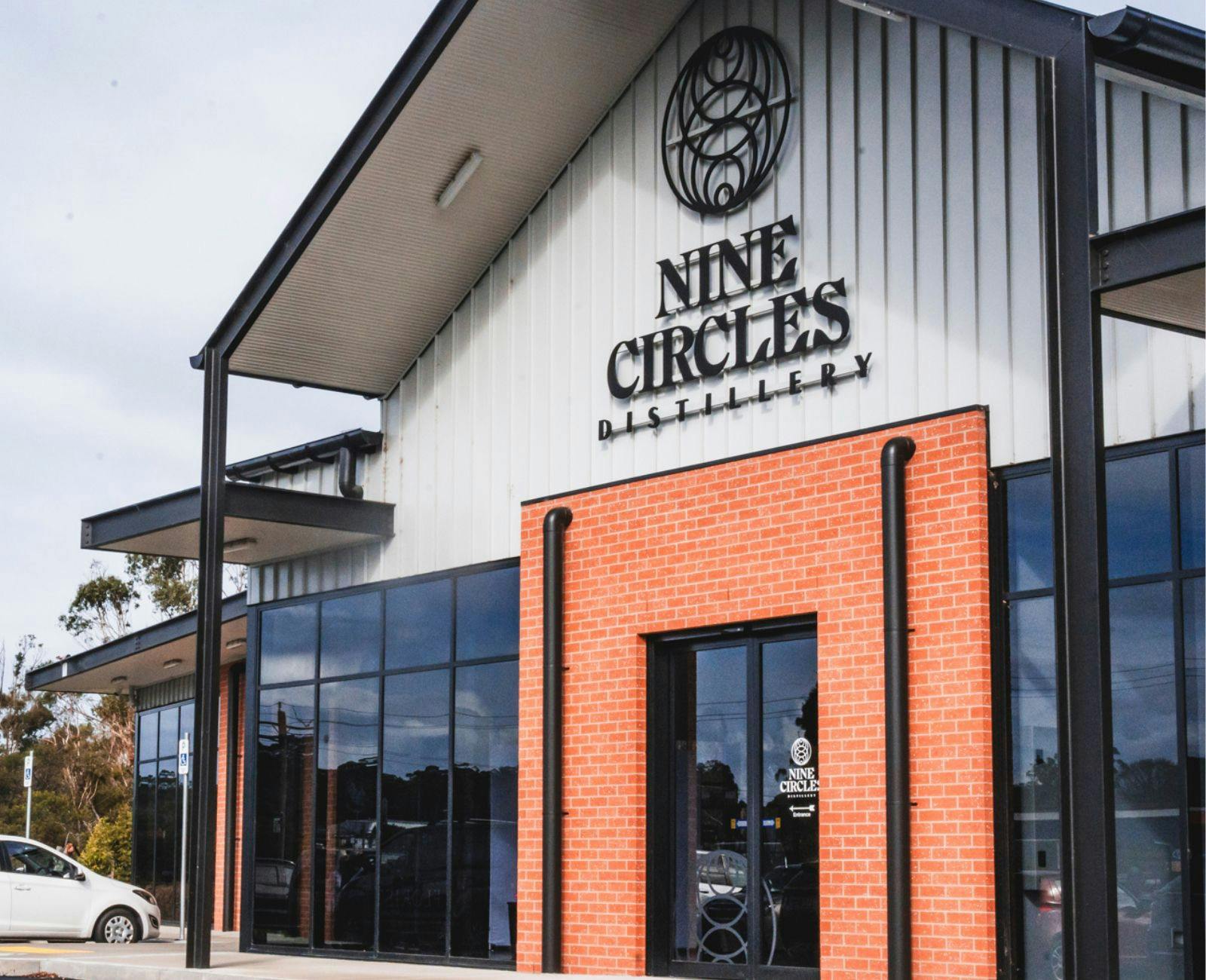 Shows the front of Nine Circles Distillery with signage and brickwork