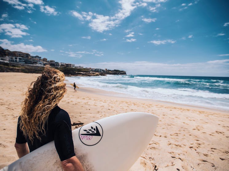 Surfer heading out to catch a wave at Bronte Beach, Sydney