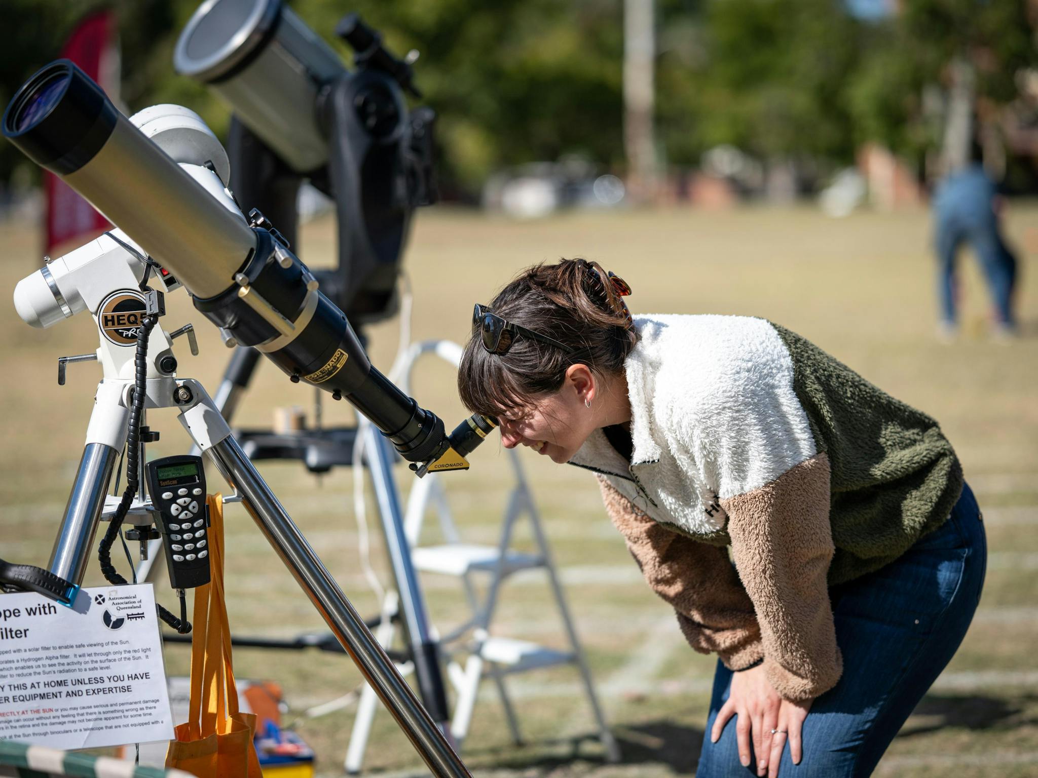 A lady looks through a solar telescope in broad daylight A lady looks through a solar telescope in broad daylight