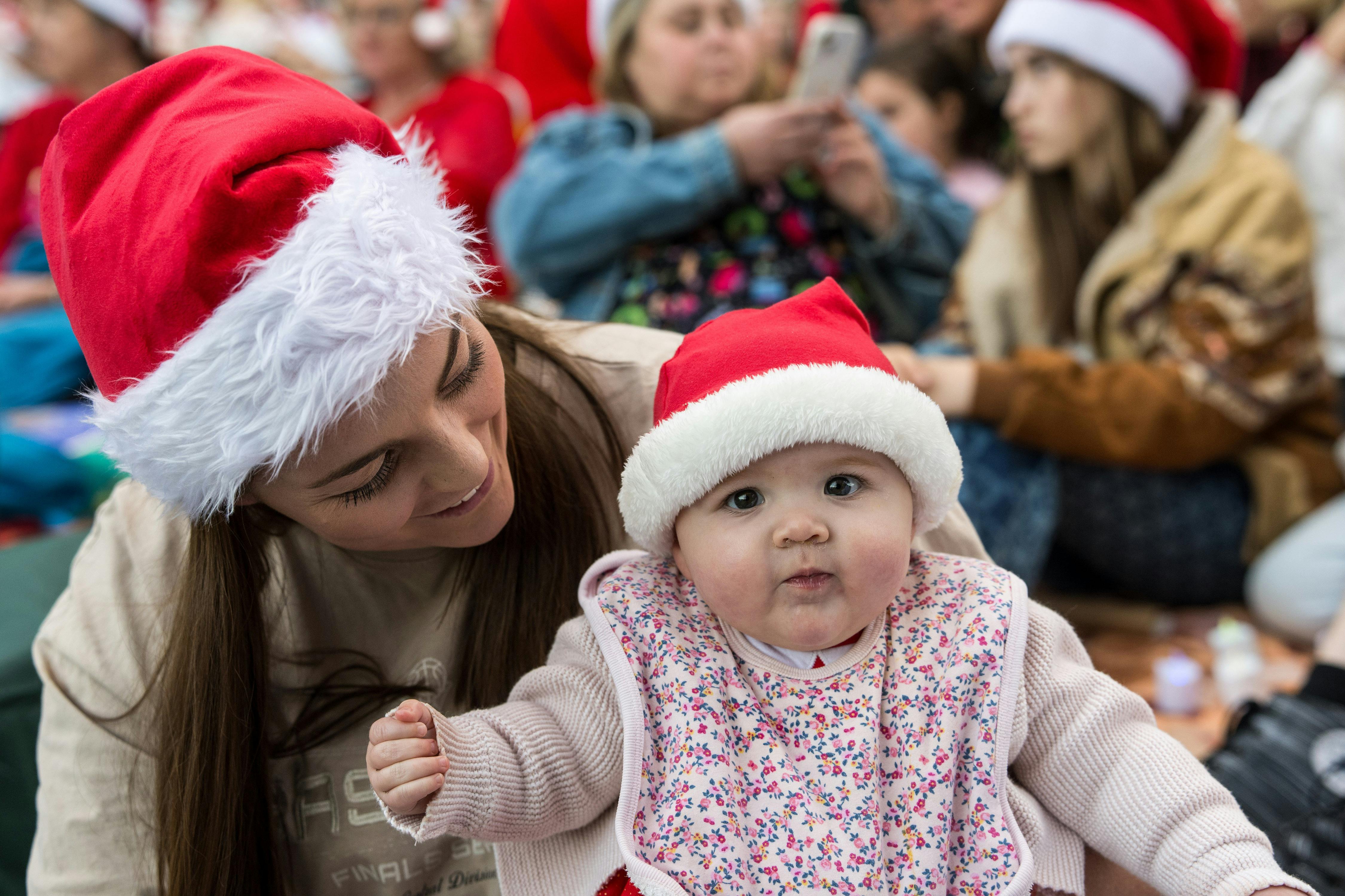 Mum and baby both with santa hats