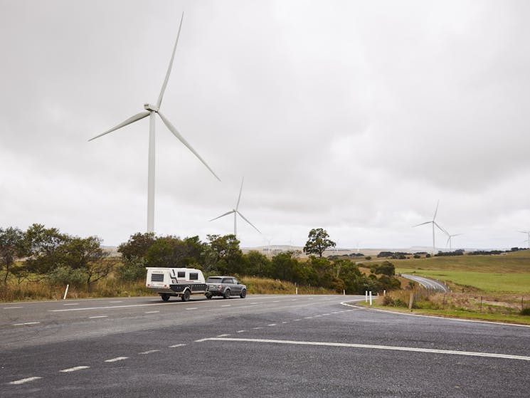 Crookwell Wind Farm with caravan and car driving through foreground