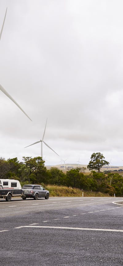 Crookwell Wind Farm with caravan and car driving through foreground