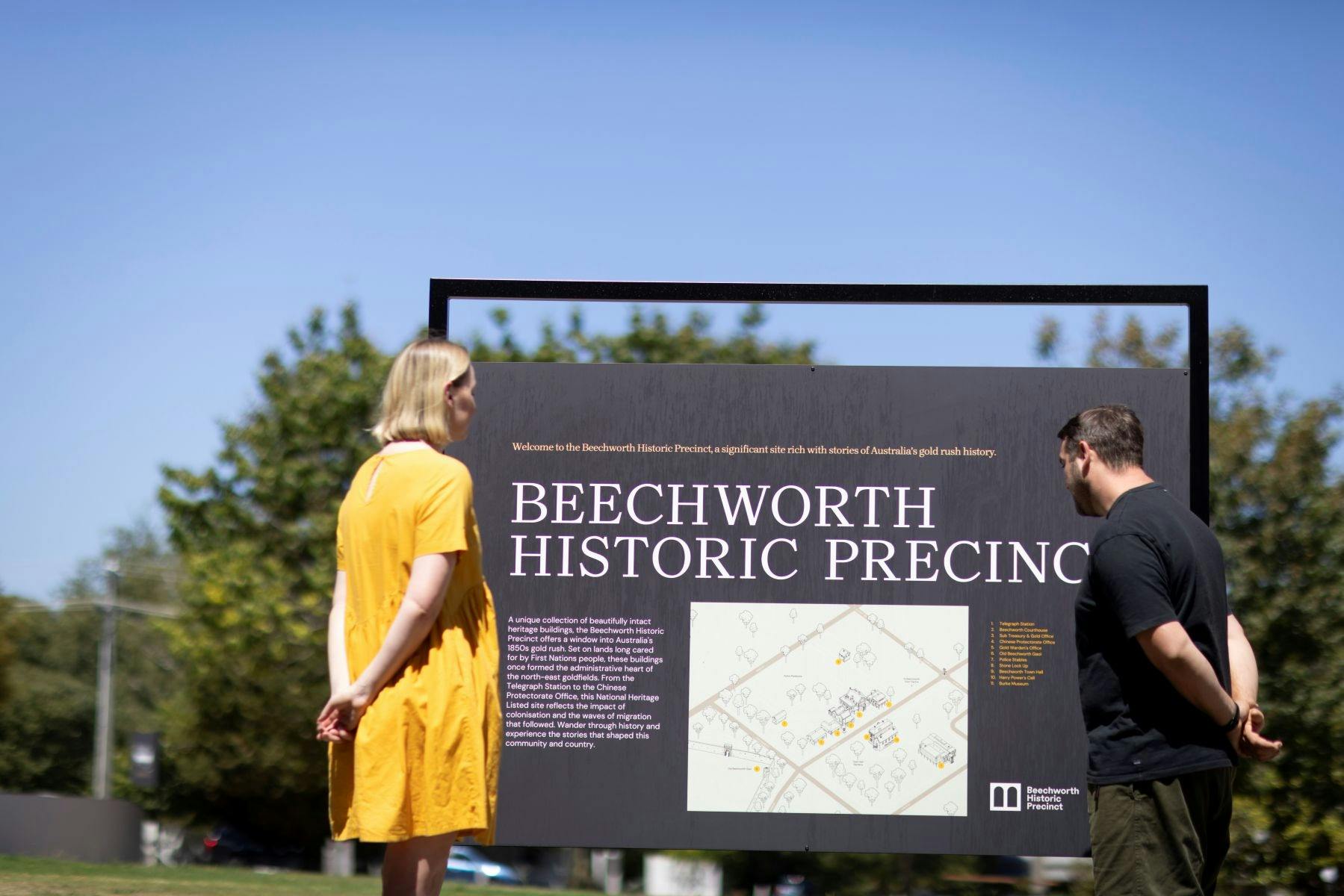 a couple looking at a large interpretive sign