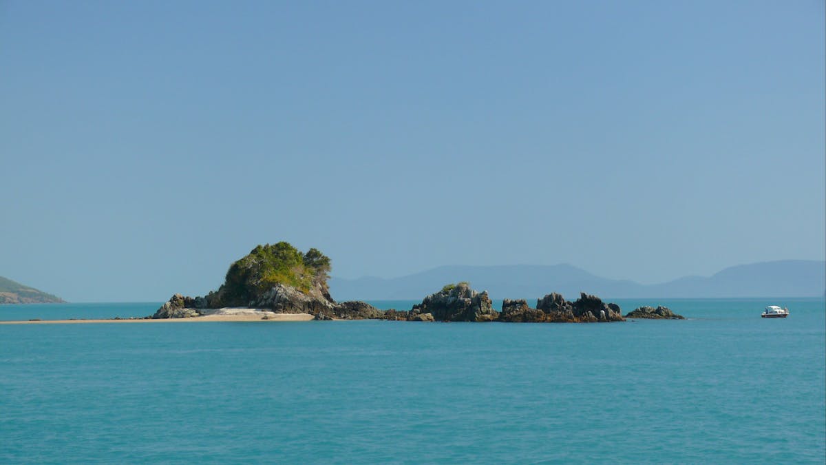 Full view of the small and rocky Henning island with  a stretch of sand on the left side
