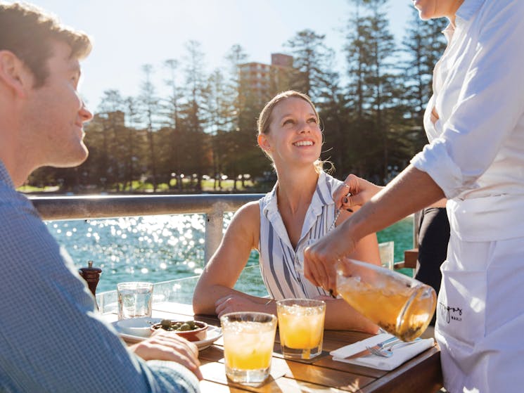 Couple enjoying food and drinks at Hugos Manly, at Manly Wharf