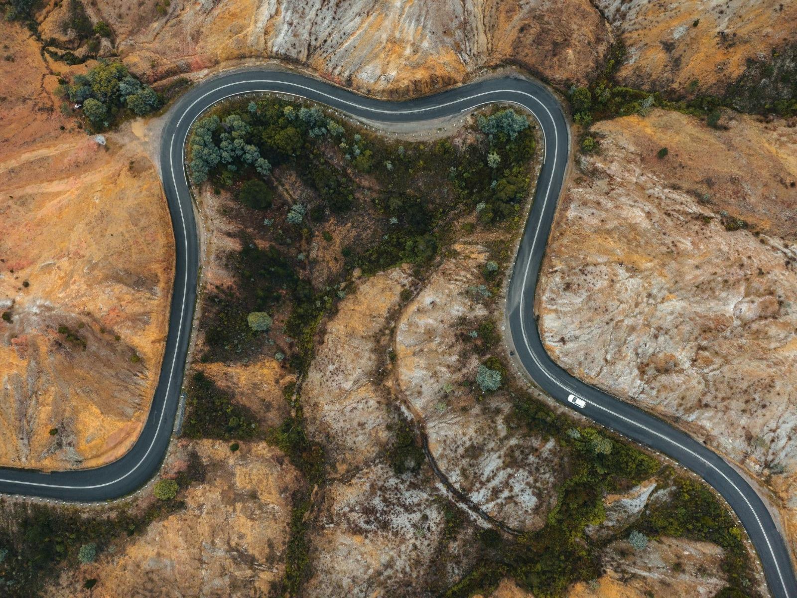 A vehicle drives along a curving road in Queenstown