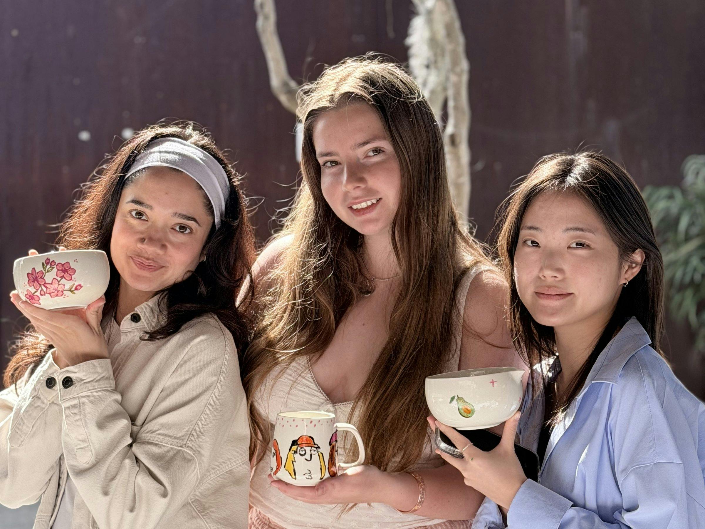 Guests holding their hand-painted ceramics at a NOA Matcha workshop