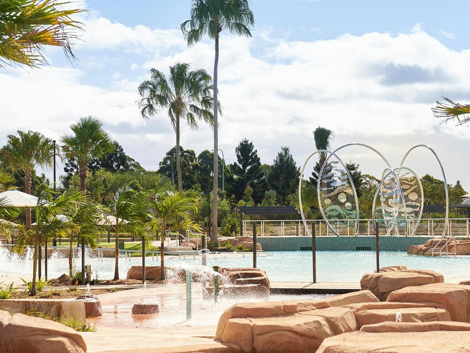 An image of a pool surrounded by rocks and trees