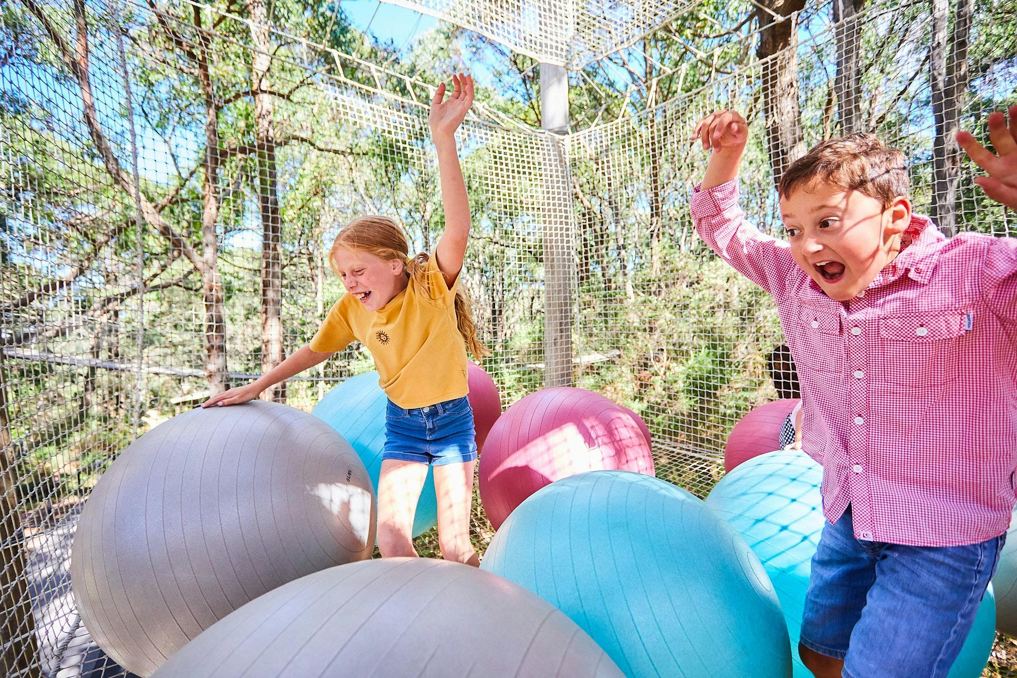 Two children play in the ball pits of the Sky Scramble at Enchanted Adventure