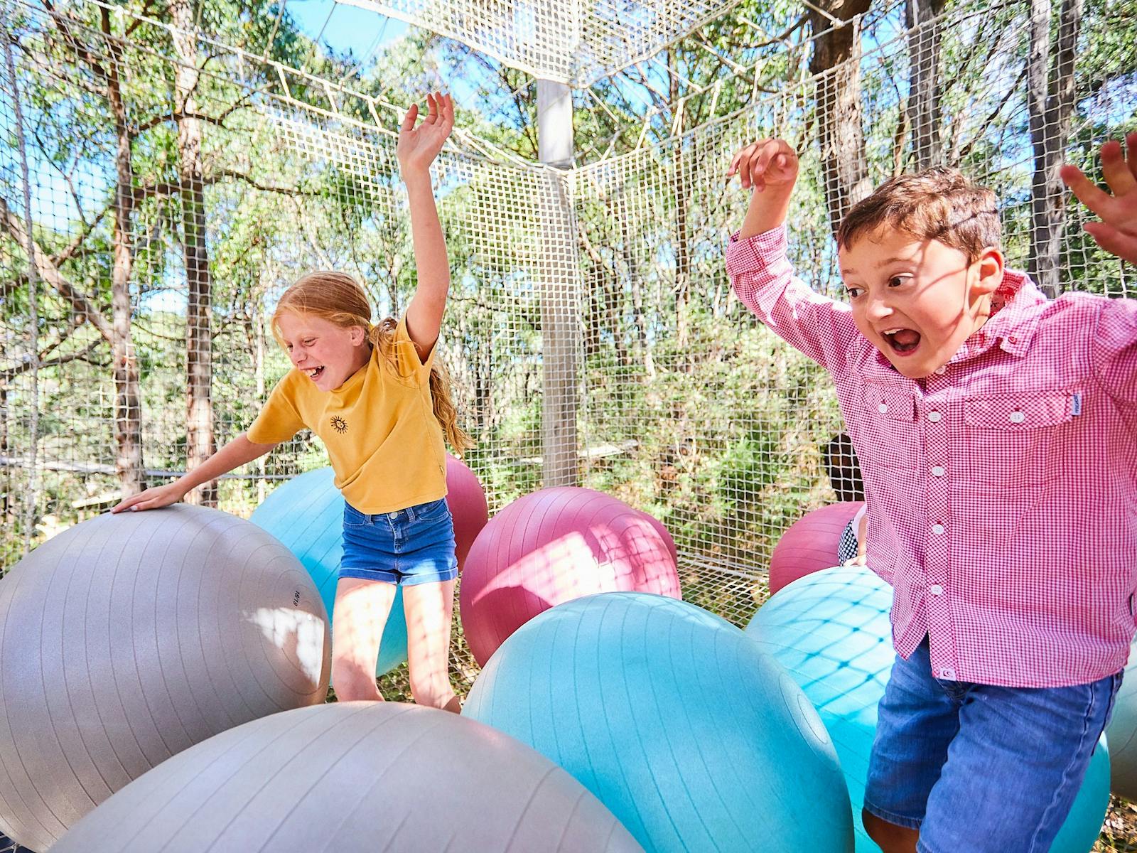 Two children play in the ball pits of the Sky Scramble at Enchanted Adventure