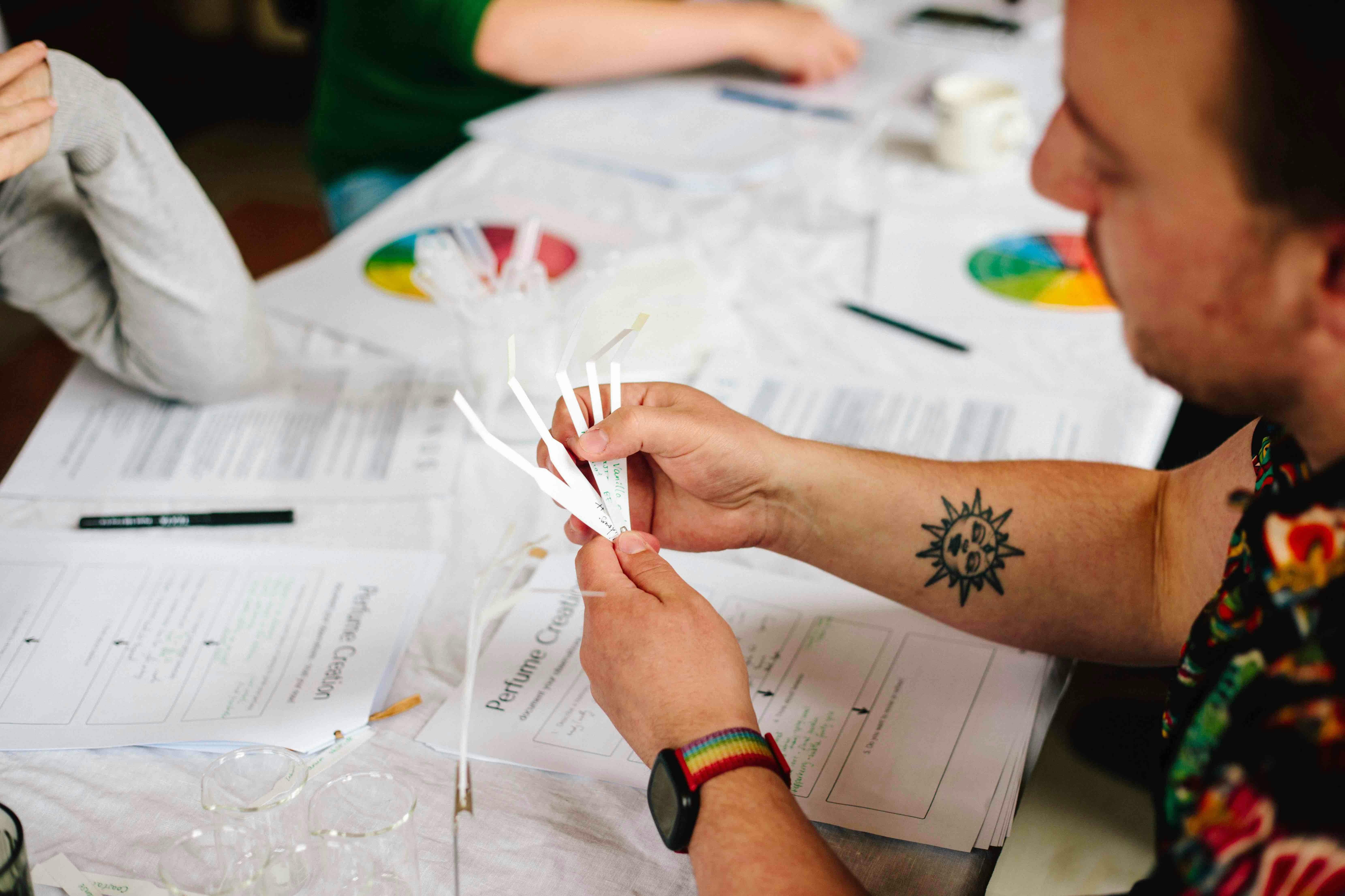 A man holds smelling strips to build a custom scent
