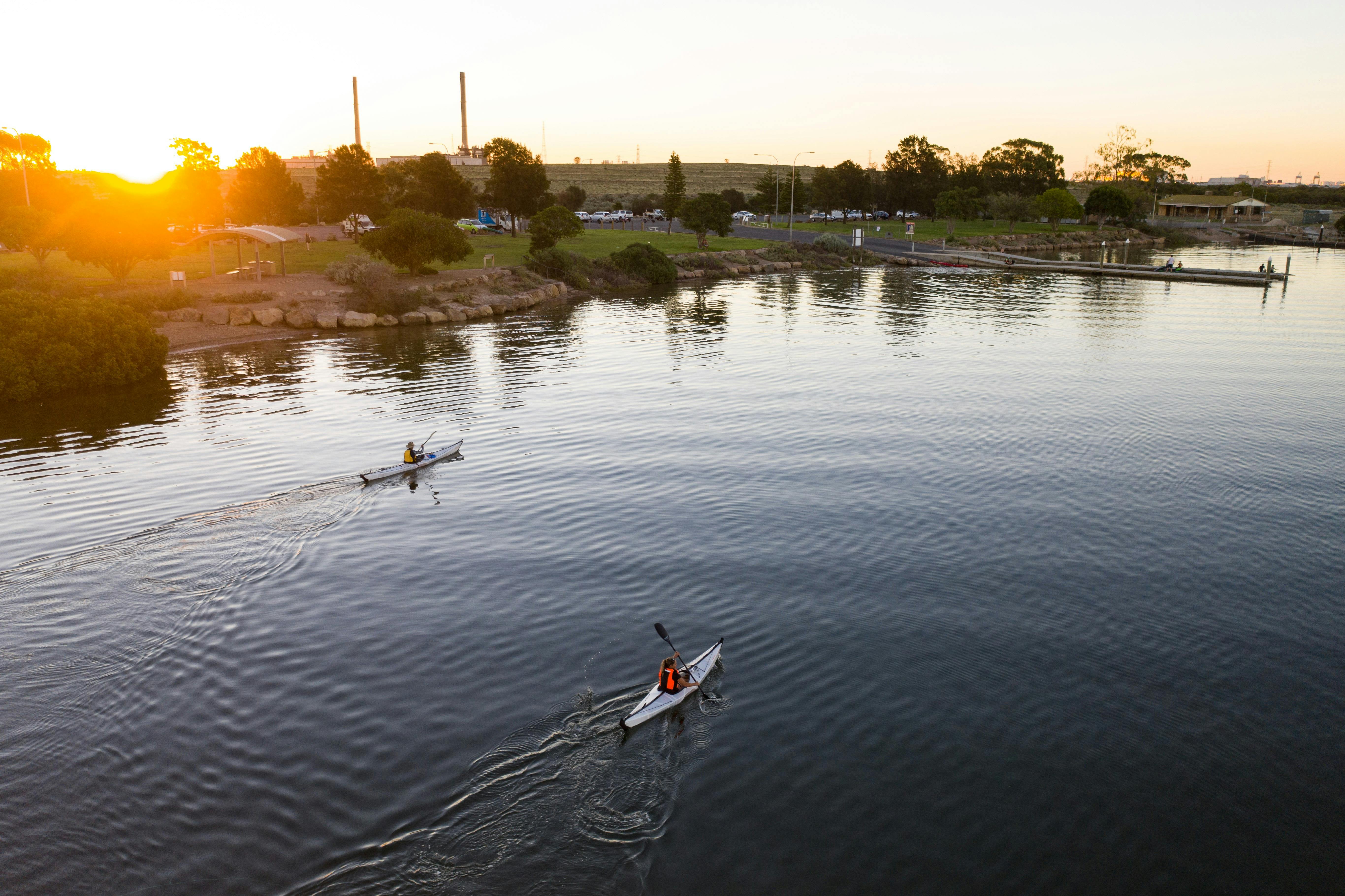 2 kayakers paddling as the sun setsyaking