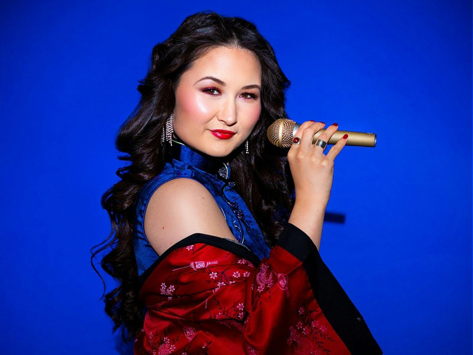 Portrait of artist with mic on a deep blue background