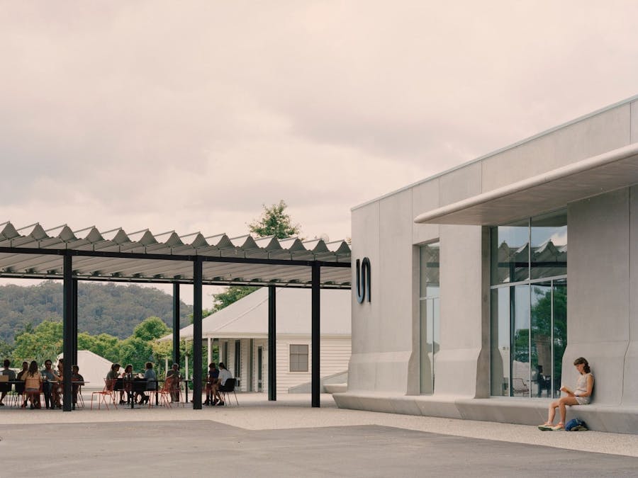 An exterior image of the concrete facade of the Art Museum and lively terrace of Ramox Cafe