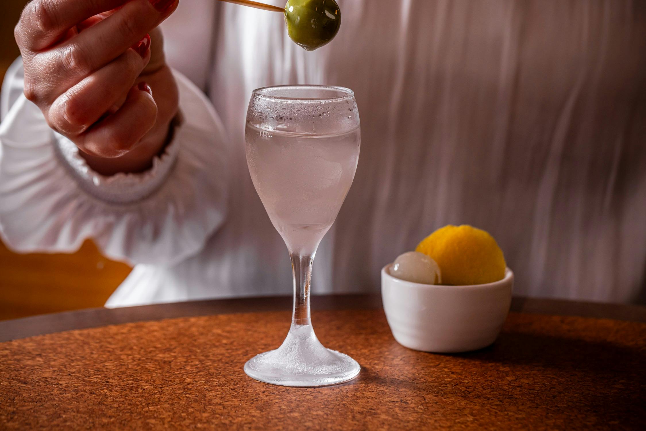 A mini martini glass with olive