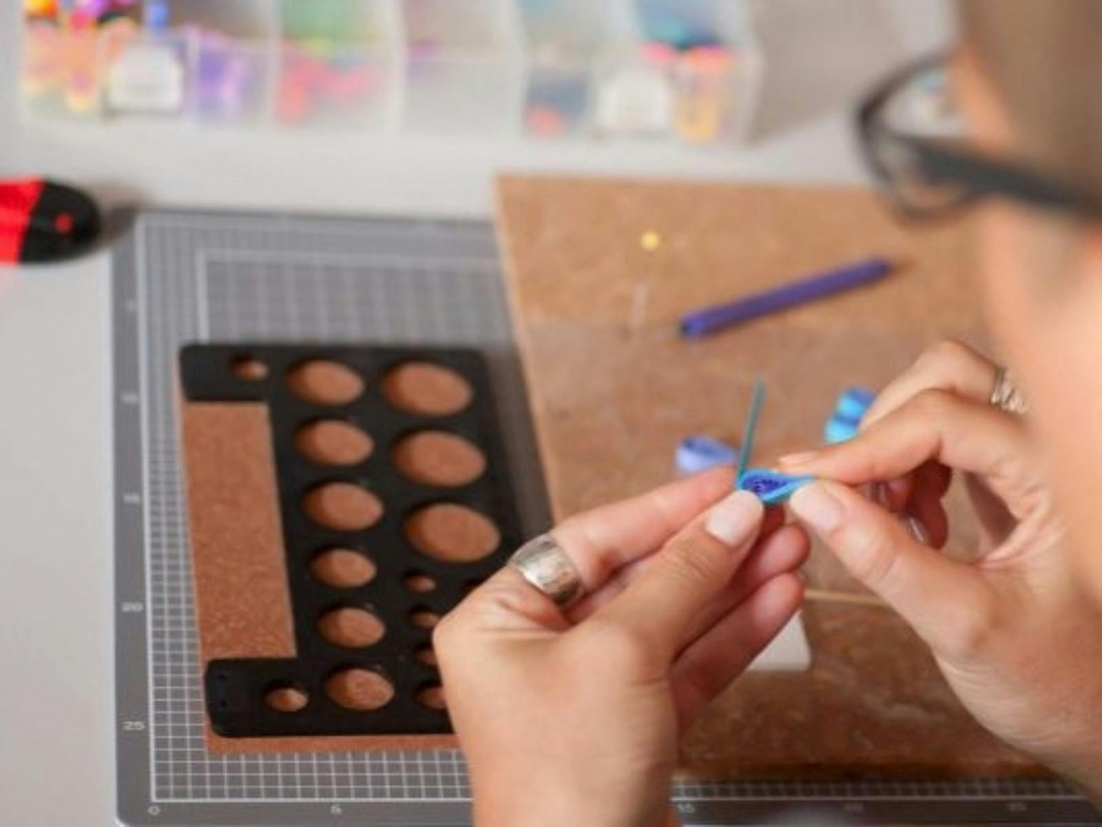 Close up image of Kath working with small, rolled paper petals to create a quilled flower.