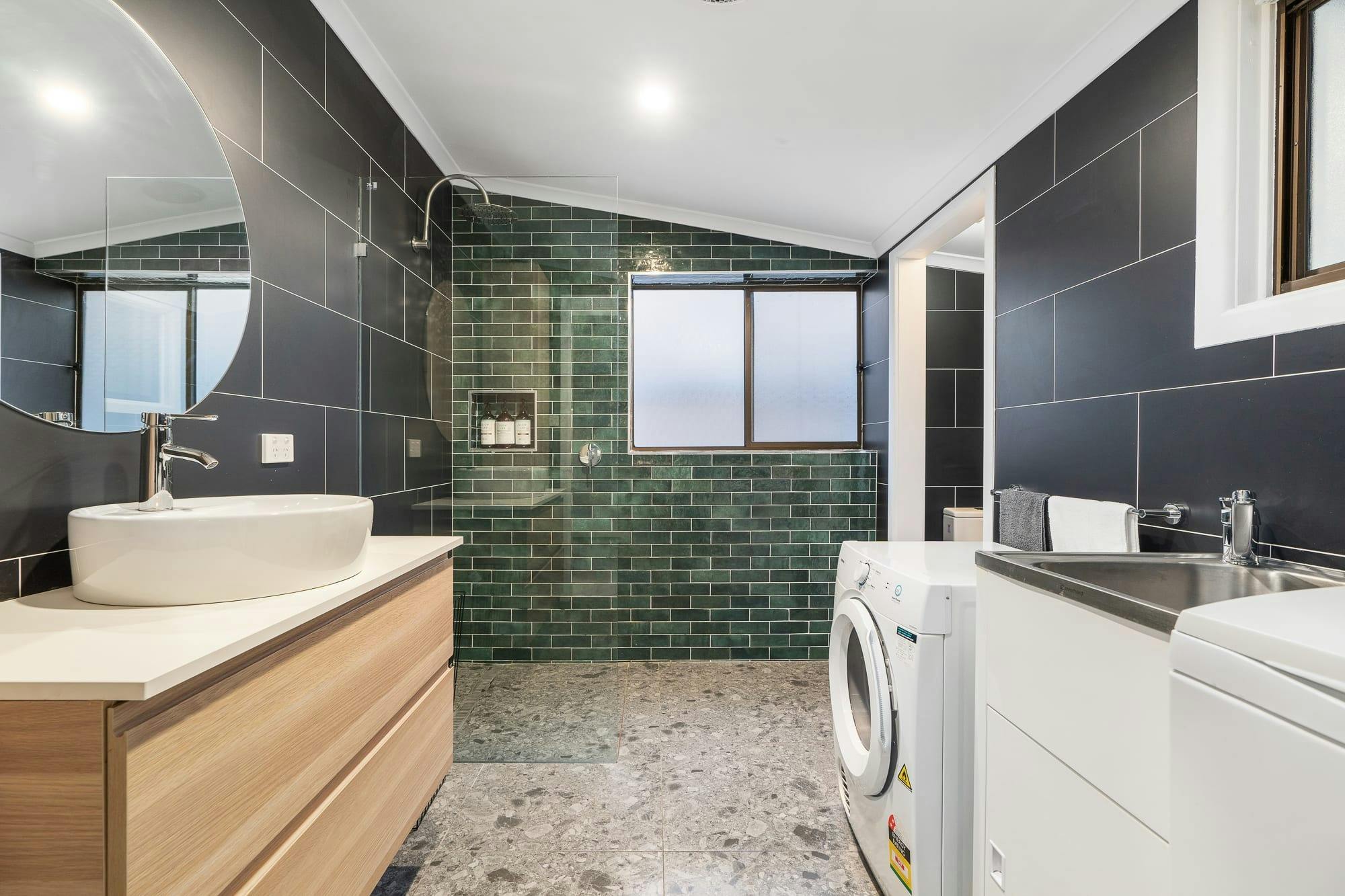 Bathroom with vanity, shower, toilet and washing machine