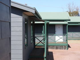Exterior view of Port Lincoln Villas with grey painted walls, green railings and villa entrances.