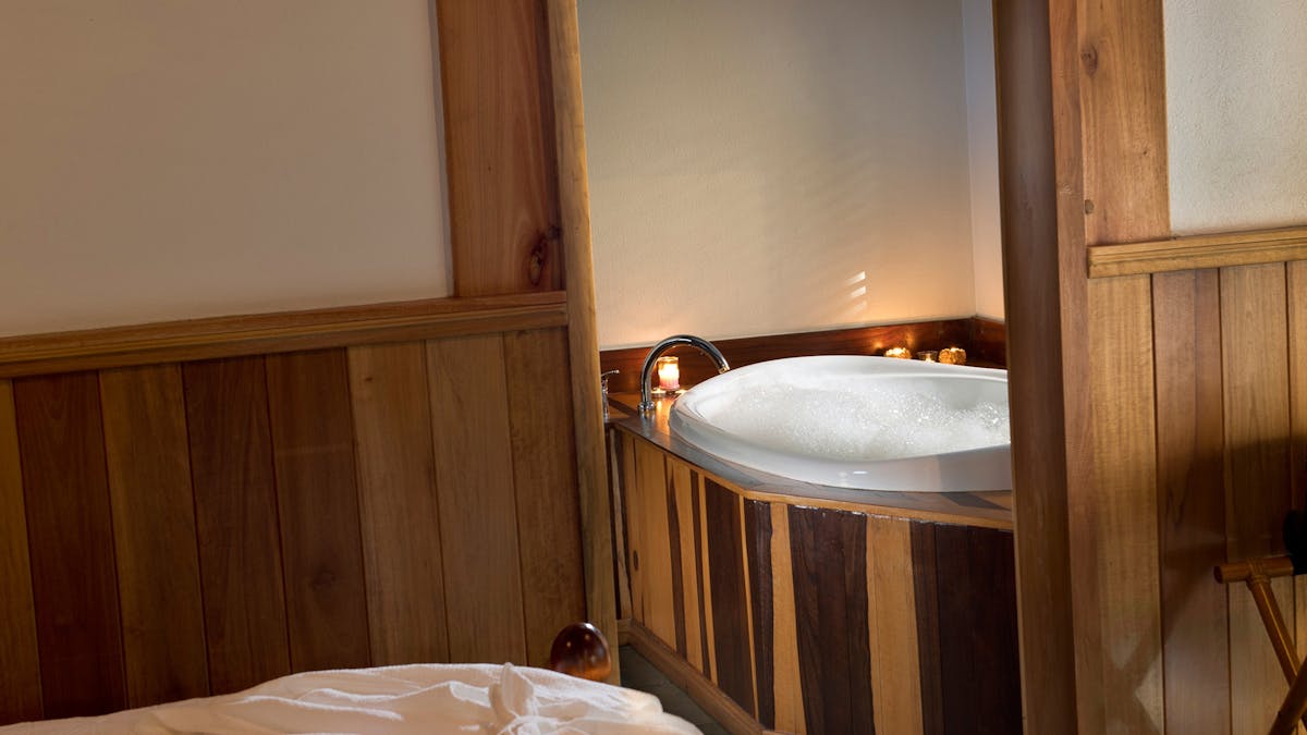 alt="Bedroom and heated spa bath at Sharlynn"