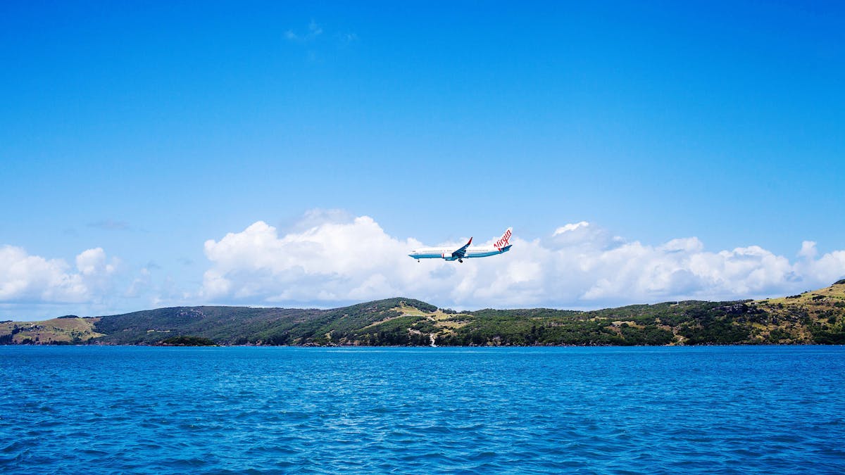 Plane about to land on the island airport strip close to the water
