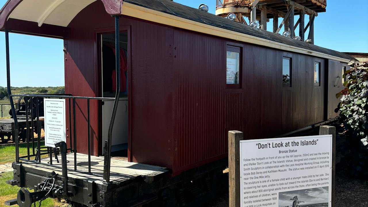 Scale adjusters van/ ticket office with description of "Don't Look at Me" statue and old water tank