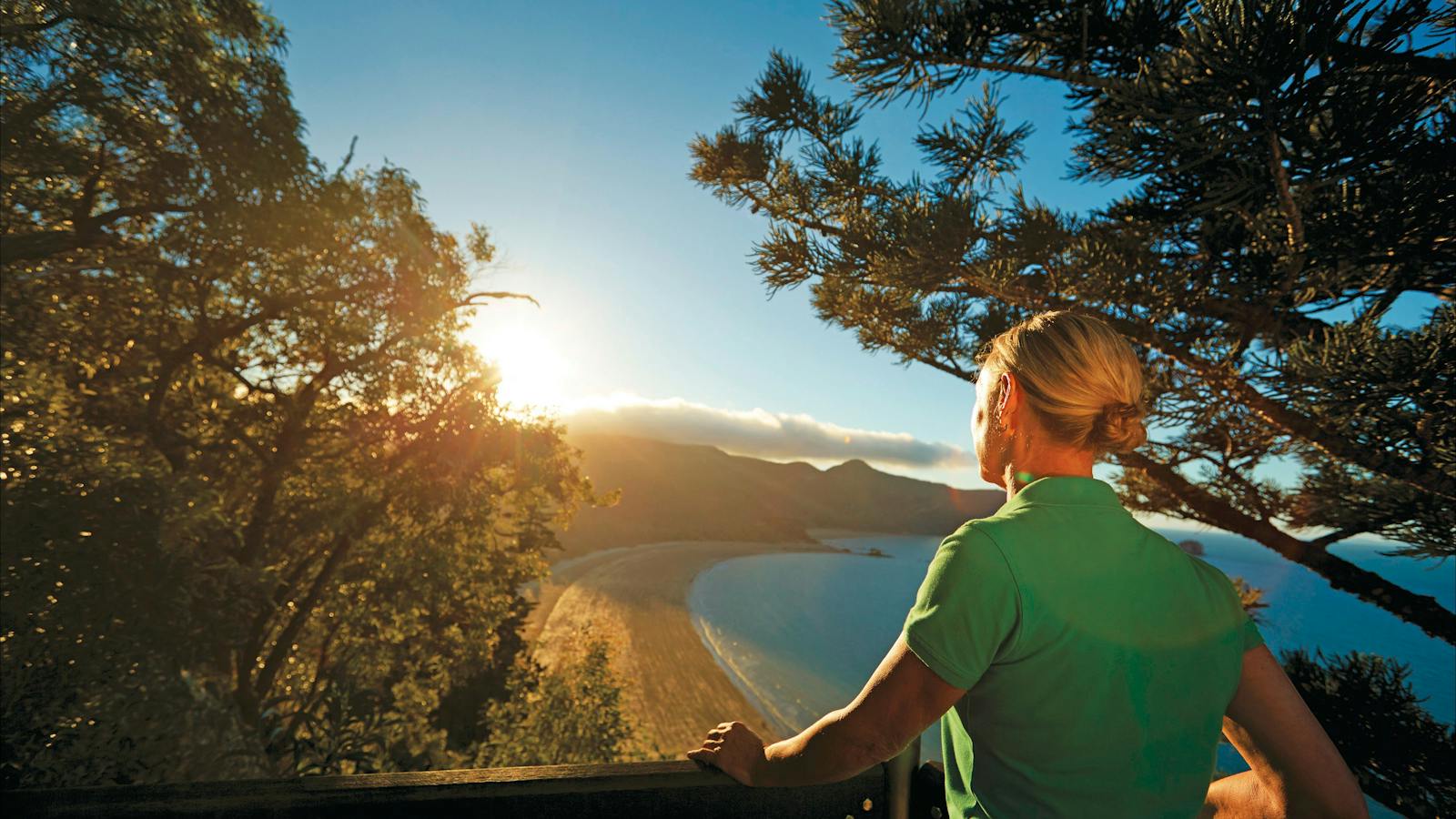 Woman looking at view of ocean from walking trail