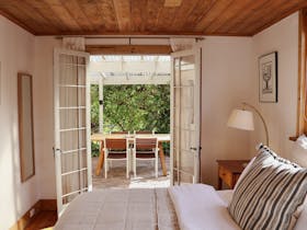 Bedroom with French doors opening to outdoor courtyard at 1856 Cottage in Robe South Australia