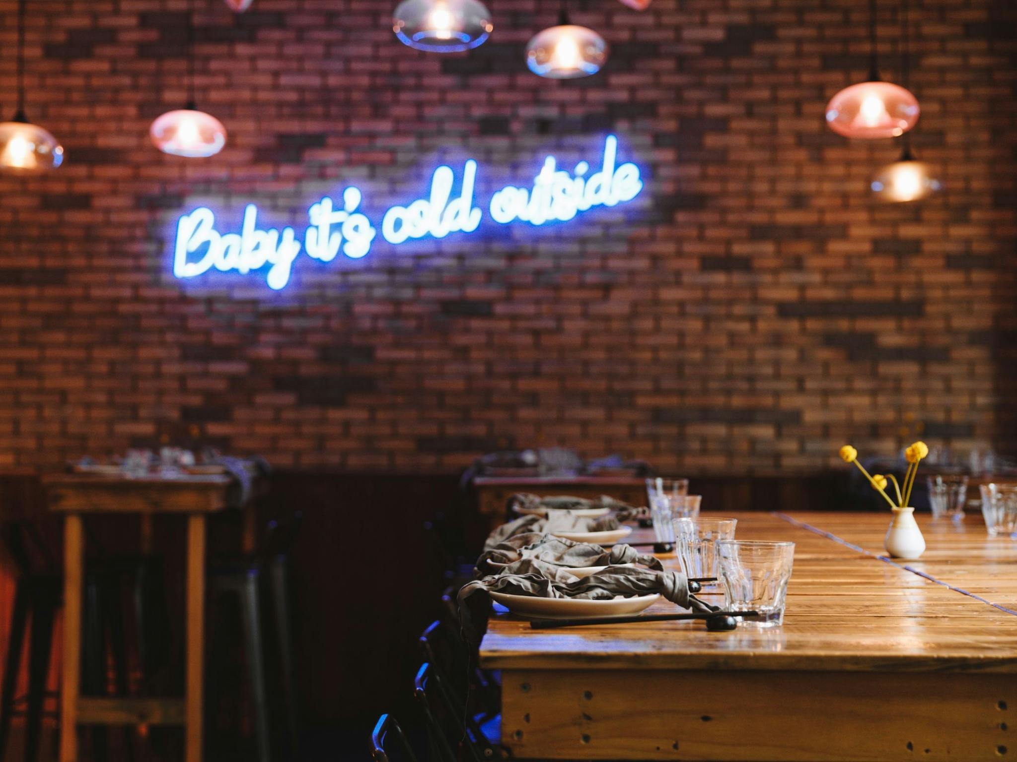 The interior dining area of Huski Kitchen featuring a blue neon sign