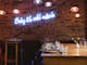 The interior dining area of Huski Kitchen featuring a blue neon sign