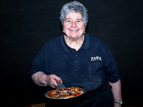 Mrs Zema holds pizza at Zema Estate event