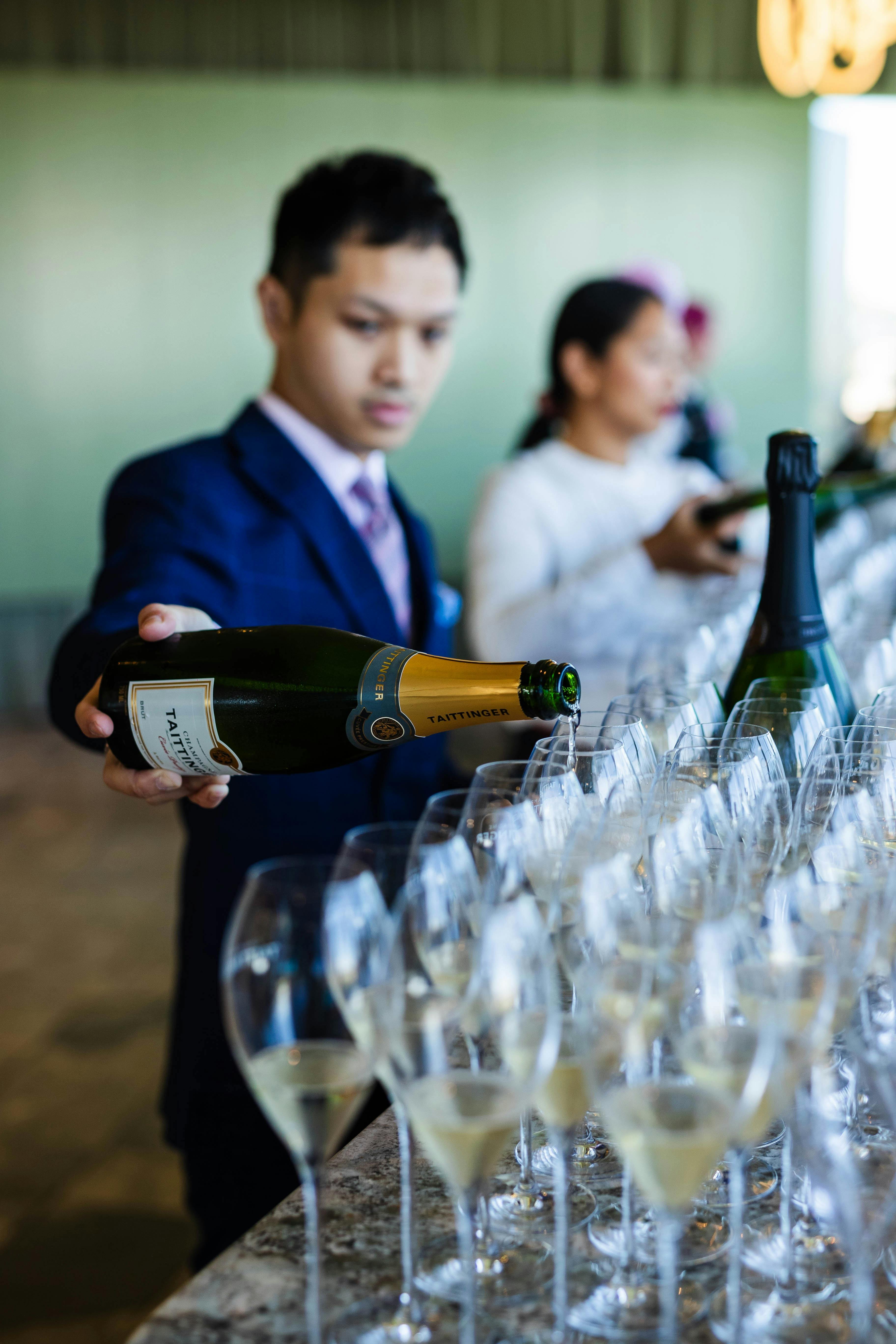 Bar staff pouring glasses of champagne