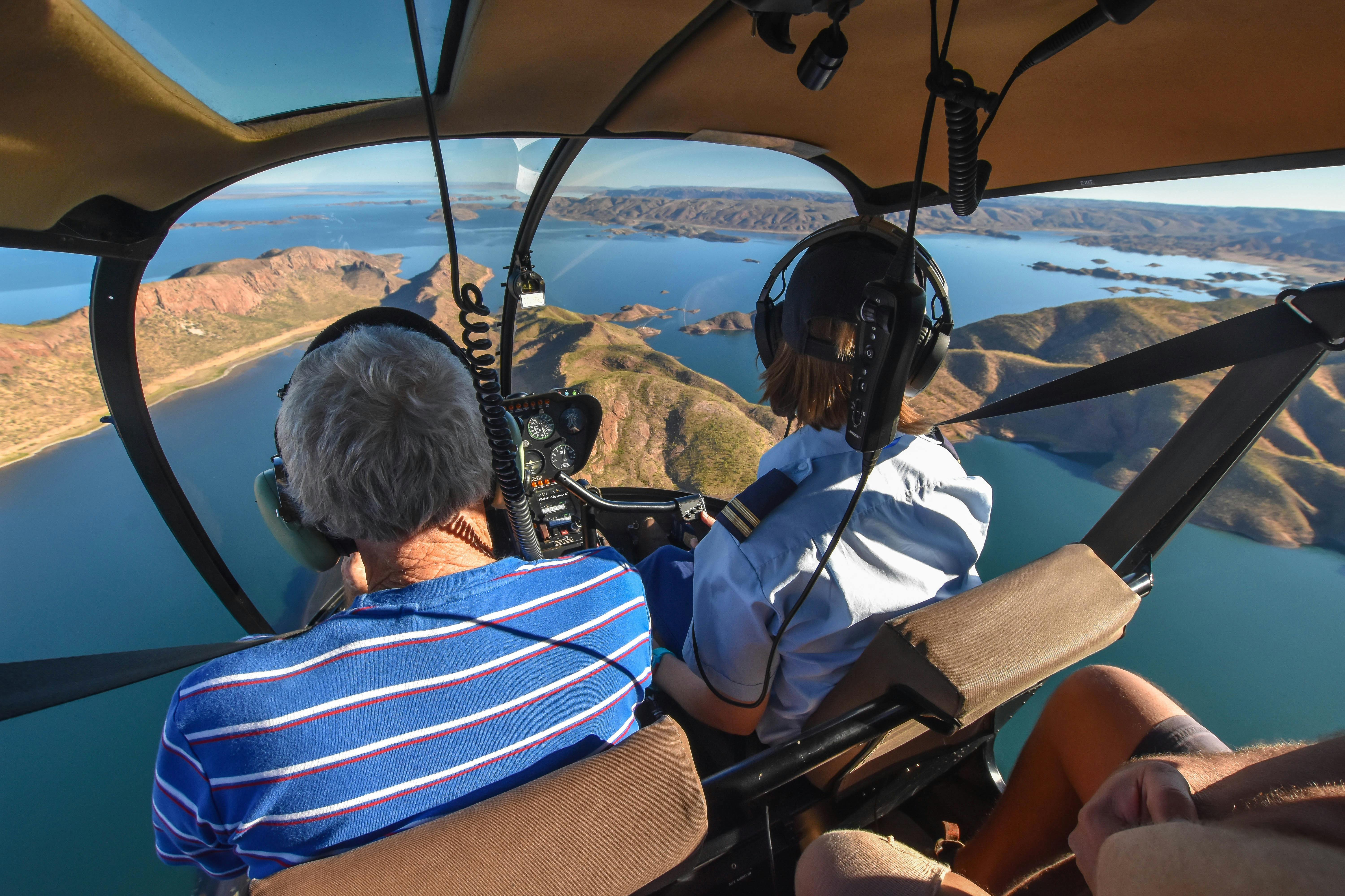 Two people in helicopter flying over Lake Argyle